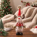 Nahaufnahme einer Plüsch-Rentierpuppe mit rotem Strickhut in Weihnachtsdekoration - Stehendes Rentier