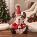 Detailansicht einer süßen Rentier-Plüschpuppe mit roter Strickmütze und Schal für Weihnachten - Sitzendes Reh