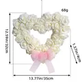 White heart-shaped rose wreath with pink ribbon and size dimensions, 35cm x 32cm. - White