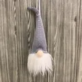 Gray knitted Christmas gnome hanging ornament with white beard and wooden background - Gray