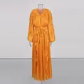 Detail view of an orange pleated maxi dress with silky fabric and ruffle details. - Yellow