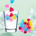 Gros plan de glaçons en plastique réutilisables en forme de cœur colorés dans un verre d'eau - Forme de Cœur 24 Pièces