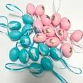 Detail view of 4cm blue and pink plastic Easter eggs with rabbit patterns and ribbons. - Style E / 24 Count (4cm)