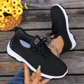Detailed view of the breathable black mesh upper and soft cushioning sole of walking shoes - 37 / Black