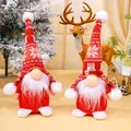Pair of Christmas gnomes with red knitted snowflake hats for holiday table decoration. - Red