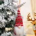 Detail of a red knitted Nordic gnome ornament hanging on a snowy Christmas tree - Style F