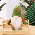 Christmas faceless gnome doll ornament in green and orange, sitting on a wooden bench. - Green Button Hat Style