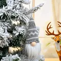 Detail view of a knitted grey and white Christmas gnome ornament hanging on a tree - Style G