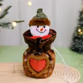 Detail shot of a festive Christmas snowman candy bag featuring a plush head and red heart - Heart Window Snowman