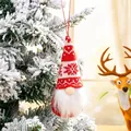 Red and white knitted Christmas gnome ornament hanging on a snowy tree - Style E