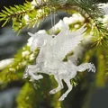 Detailansicht eines transparenten Acryl-Einhorns als Weihnachtsbaumschmuck im Schnee. - Transparentes Acryl Pegasus