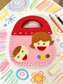 Detailed view of kids' DIY handmade felt sewing bag with cute cartoon character faces - Boy and Girl Bag