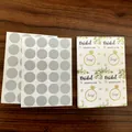 Detailansicht von Brautparty-Rubbellosen und silbernen Aufklebern auf einem Holztisch - 48 Stück/Packung