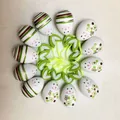 Detailed view of 12 Easter egg ornaments with smiley faces and green felt leaf hangers. - Assorted Style Set / Set of 12