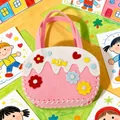 Handmade pink DIY felt handbag for kids featuring colorful flower and heart-shaped patterns. - Cake