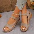 Macro view of stylish brown wedge sandals featuring Velcro straps and white stitching - Khaki