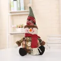 Macro view of plush Christmas snowman doll featuring a festive plaid hat and red scarf - Snowman