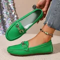 Detail view of vibrant green loafers with textured leather and a stylish metal buckle. - Green