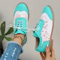 Dettaglio delle scarpe Brogue da donna con motivo floreale verde acqua e lacci bianchi. - 36 / Ciano