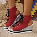 Detailed view of red canvas lace-up wedge sandals featuring a silver woven platform heel - 38 / Red