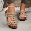 Nahaufnahme von beigen flachen Sandalen mit geometrischen Ausschnitten und Schnallen. - Beige