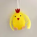 Detalle de un adorno de huevo de Pascua con pollito de plumas amarillas y fieltro - Altura aprox. 6cm / Amarillo