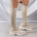 Botas altas de punto beige con suelas de plataforma blancas vistas en modelo. - 36 / Beige