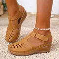 Close-up of tan wedge sandals with white stitching and closed-toe cutout design - Tan