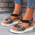 Stylish wedge sandals with zebra print straps and gold ring hardware in white finish. - 36 / Black