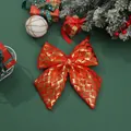 Detailed view of a red and gold metallic Christmas bow on festive green background - Reddish Brown 425 (328.10) / 20*25cm / Red Brown