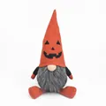 Detail shot of a Halloween gnome ornament with orange pumpkin face and fluffy beard. - Orange Pumpkin Hat Gnome / Orange Red