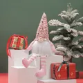 Close-up of a pink sequined Christmas gnome doll sitting among festive gift boxes - Hat Style 4 / 16x33cm
