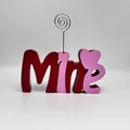 Primer plano de un letrero Mine de madera roja y rosa con clip portafotos de corazón - Estilo Mine