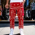 Mens red paisley bandana print cargo pants featuring side zipper pockets street style - S / Bottoms / Red