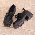 Classic black platform loafers with thick lug soles shown on vintage newspaper backdrop - 35 / Black