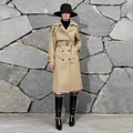 Full-length view of a stylish khaki belted trench coat paired with a black hat and boots - XS / Gold Brown