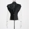 Detailopname van zwart patchwork gilet met krokodillenstructuur op transparante pop - S / Tops / Zwart