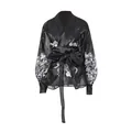 Detailed view of black sheer palace style blouse with white floral prints and tie-waist. - S / Tops / Black