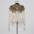 Detailweergave van luxe goudkleurige kralensjaal met elegante lange franjes design - Tops / Goud