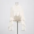 Detailweergave van de elegante ruchesmouwen op deze Franse nude roze blouse - S / Tops / Broken Wit