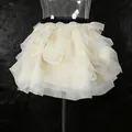 Detailed view of the elegant cream tiered ruffle mini skirt with a black elastic waistband - S / Bottoms