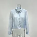 Elegant French-style light blue lace blouse with long sleeves and beaded collar detail - Blue