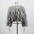 Detail van een elegante grijze korte blouse met gelaagde ruches en een ronde hals. - Grijs