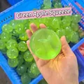 Gros plan d'un jouet antistress en forme de pomme verte tenu à la main au bureau - Forme de Pomme Verte (Avec Feuille)