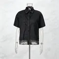 Detalle de camisa negra de manga corta con bordado floral y dobladillo calado. - S / Tops / Negro