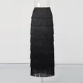 Detailed view of the layered black fringe design on this elegant high-waisted maxi skirt. - M / Black