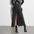 Detail of high-waisted black denim cargo maxi skirt with front slit and large pockets. - S / Bottoms / Black