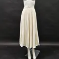 Gedetailleerde weergave van de textuur op een crème geplooide midirok met hoge taille. - S / Bottoms / Broken Wit