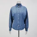 Front view detail of a retro blue denim shirt with cinched waist and button-down front. - S / Tops