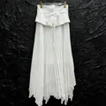 Dettaglio ravvicinato della gonna a pieghe bianca a vita alta con coulisse e orlo asimmetrico - Taglia S / Pantaloni e gonne / Bianco